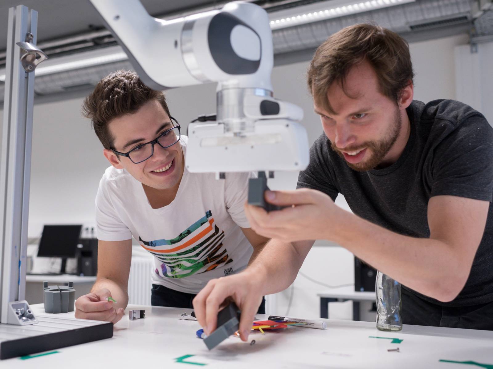 Zwei junge Menschen arbeiten an einem Roboter