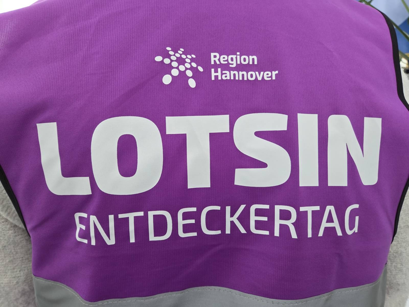 Eine lila Weste mit der Aufschrift "Lotsin Entdeckertag".