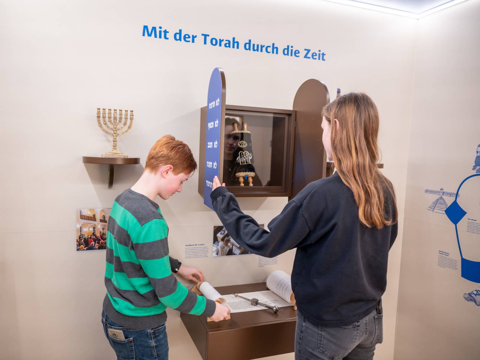 Zwei Personen betrachten Ausstellungsstücke im Haus der Religionen