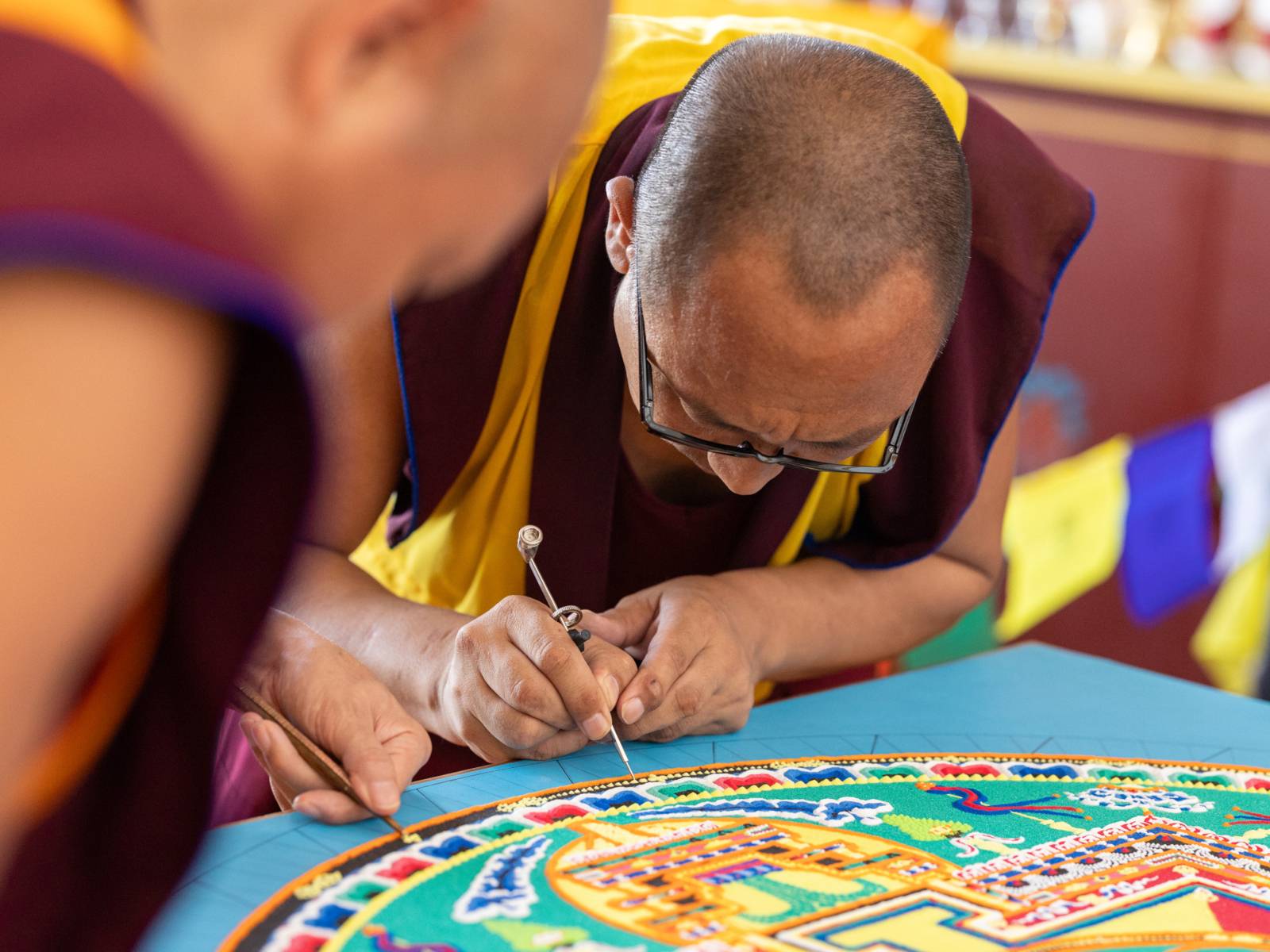 Ein Sandmandala wird gestreut