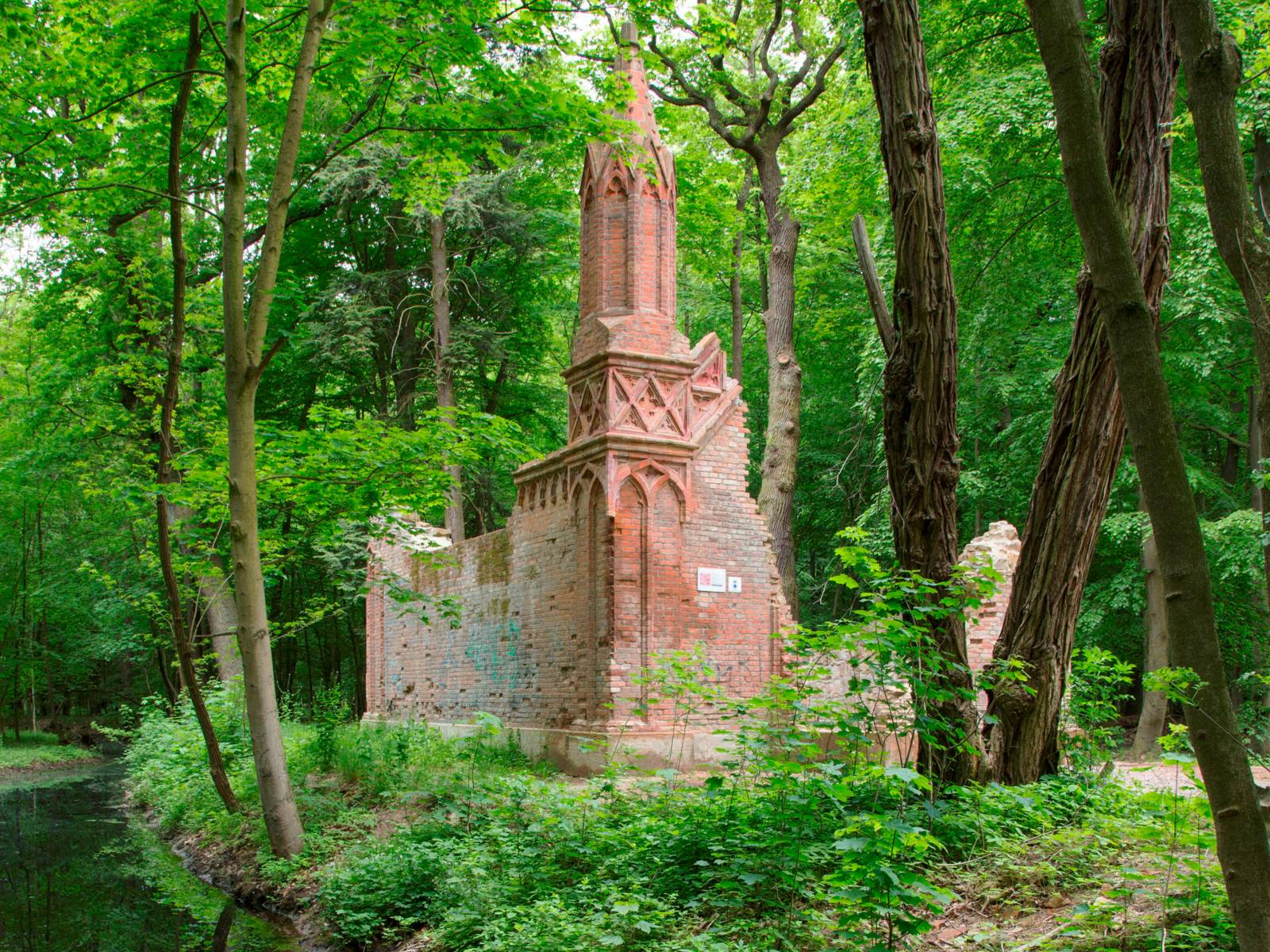 Die Ruine des Mausoleums, umgeben von Bäumen.