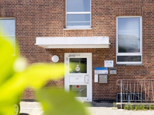 Rotes Klinkergebäude mit weißer Eingangstür