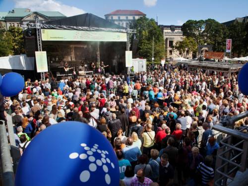 Viele Menschen verfolgen das Bühnenprogramm auf dem Opernplatz