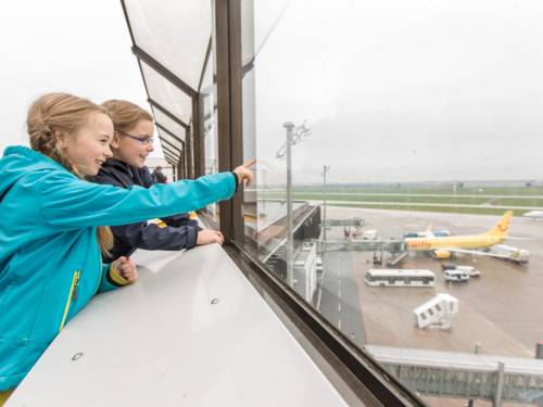 Zwei Kinder schauen auf das Rollfeld des Flughafens Hannover-Langenhagen.