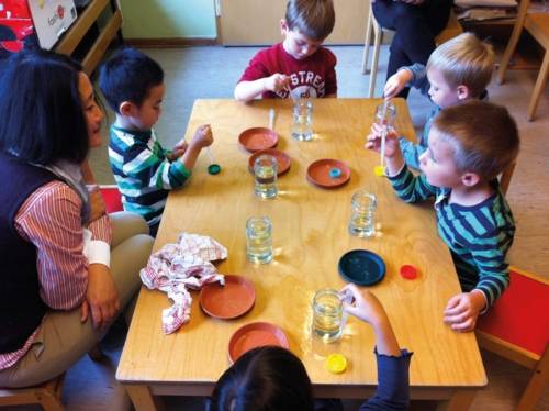 Kinder experimentieren mit Pipetten und Wasser