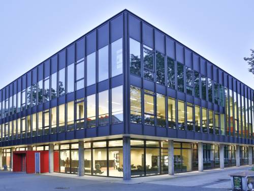 Blick auf ein zweigeschossiges Gebäude mit vielen Fenstern.