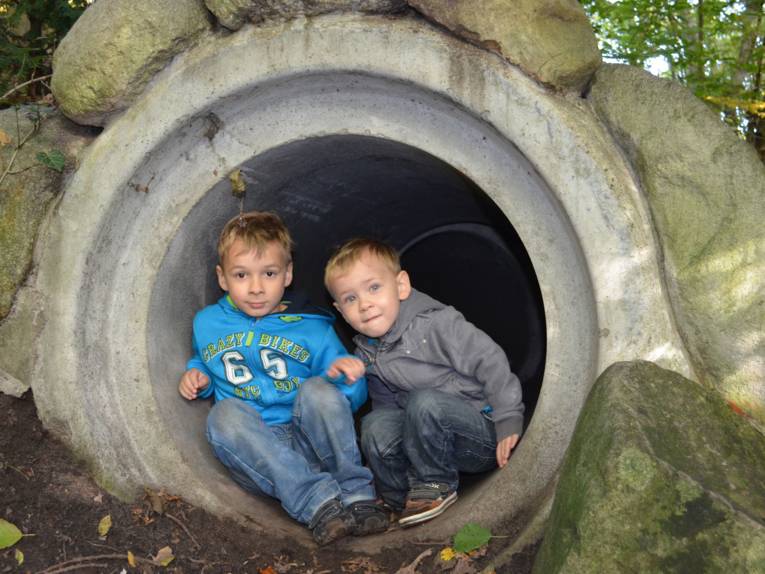 Zwei kleine Jungen erkunden eine Betonröhre