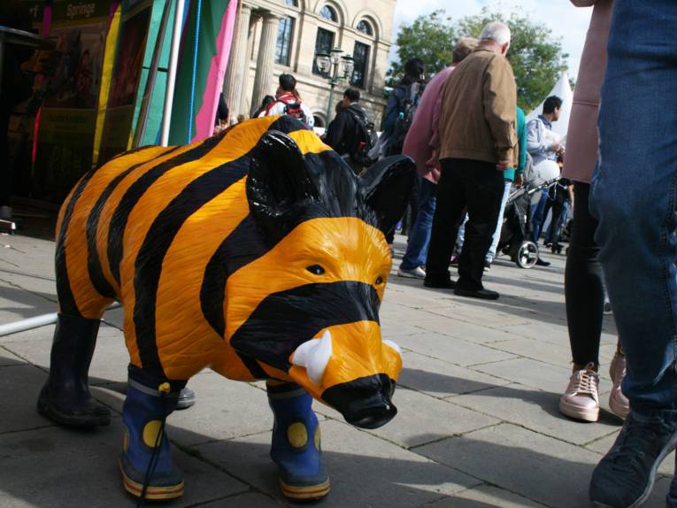 Ein unechtes gestreiftes Wildschwein, das Gummistiefel trägt.