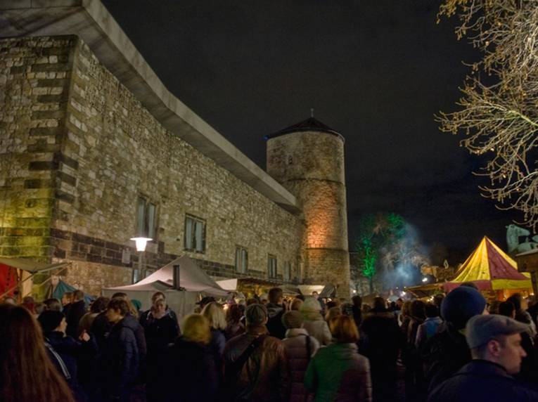 Viele Besucherinnen und Besucher des Weihnachtsmarktes zwischen Ständen, die rund um das Historische Museum platziert sind