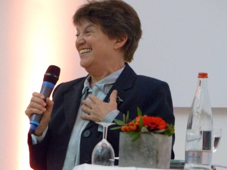 Gastrednerin Prof. Dr. Carol Hagemann-White mit einem Mikrophon am Rednerpult