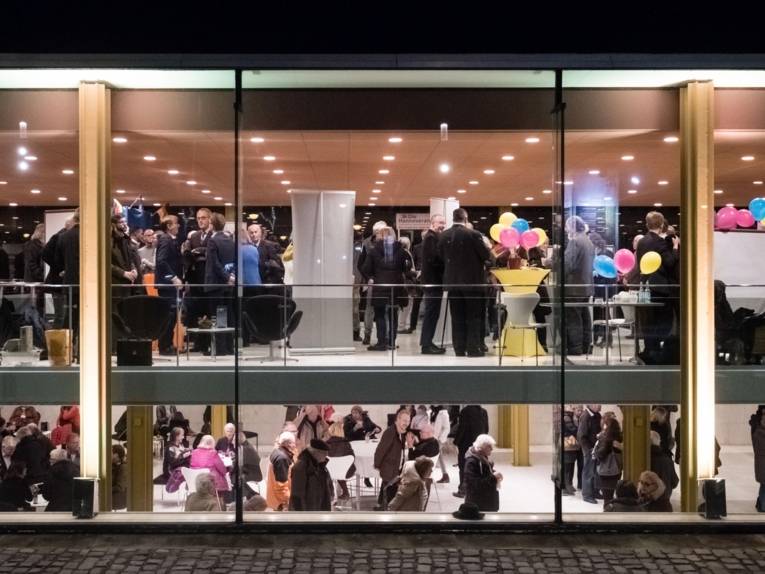 Ein Gebäude voller Menschen von außen. 