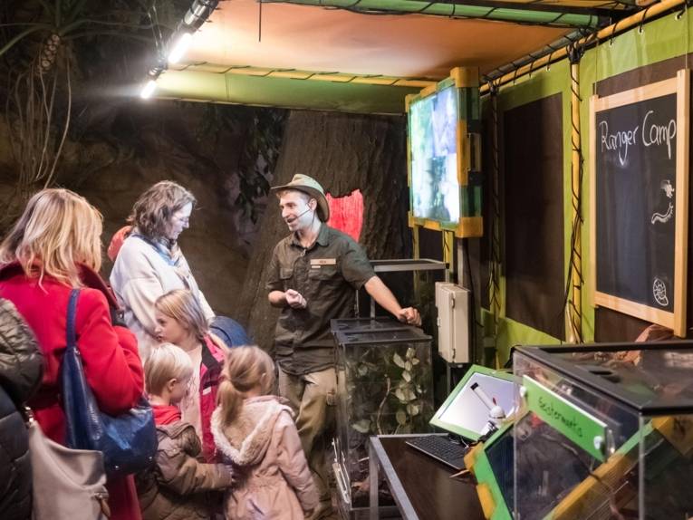 Erwachsene und Kinder, die einem Ranger zuhören. 