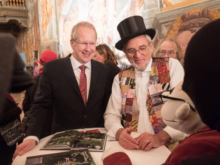 Zwei Männer bei einem Empfang. 