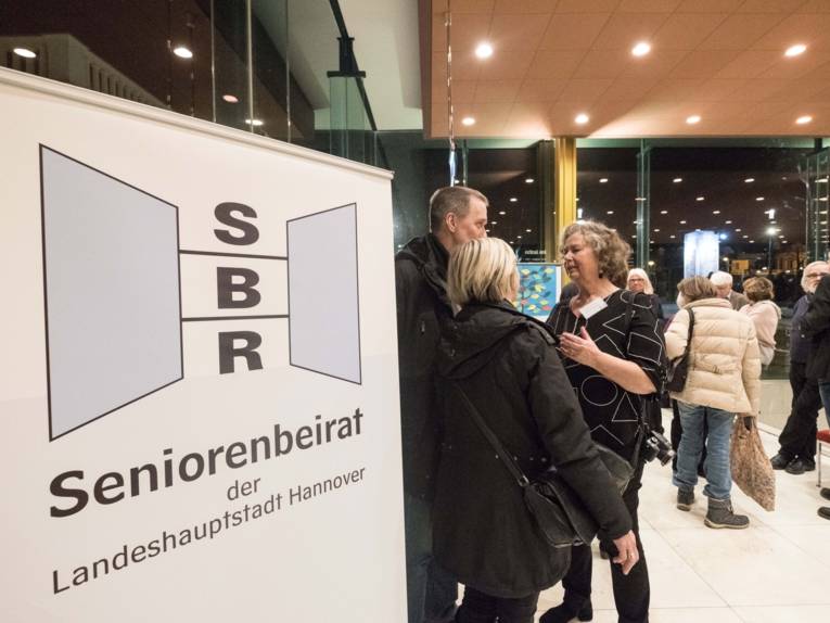 Menschen in einem Foyer. 