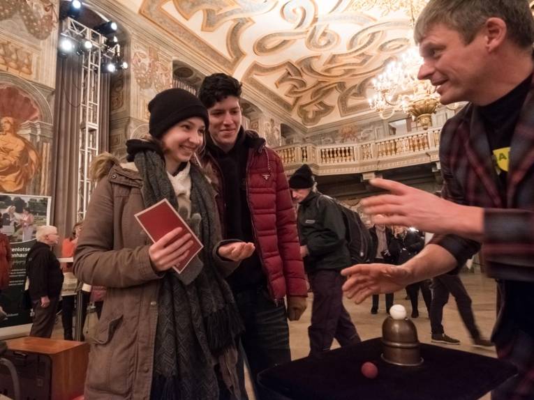 Ein Mann und eine Frau am Stand eines Trickspielers. 