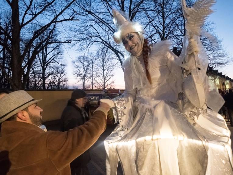 Mann, der einer als Fee verkleideten Frau die Hand reicht. 