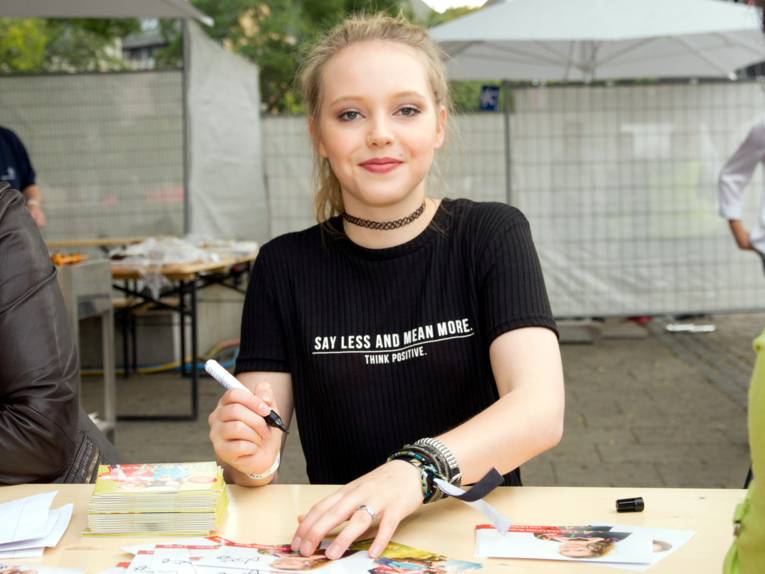 Lina Larissa Strahl sitzt an einem Tisch und hat einen dicken Filzstift in der Hand.