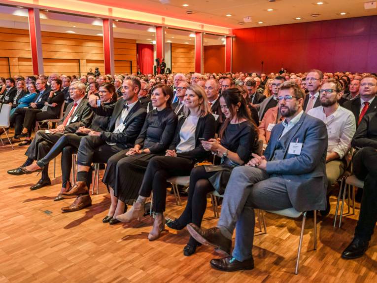 Eine große Zahl Menschen sitzend in einem Saal