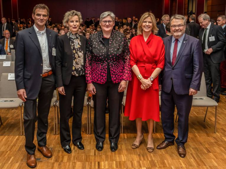 Fünf Personen in einem großen Saal