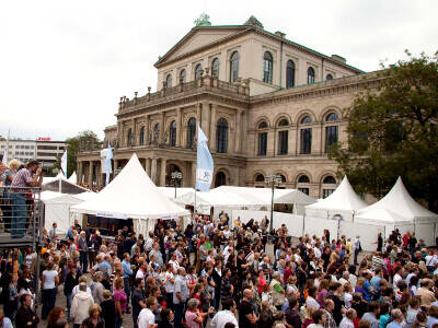 Vor dem Opernhaus in Hannover stehen weiße Pagodenzelte, eine große Menschenmenge füllt den Opernplatz. Vor dem Opernhaus in Hannover stehen weiße Pagodenzelte, eine große Menschenmenge füllt den Opernplatz.