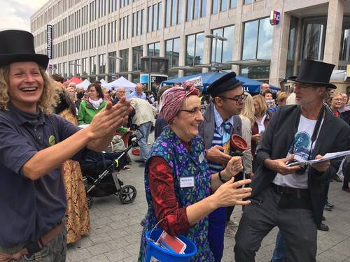 Ein Platz in einer Stadt, auf dem sich Stände und viele Menschen befinden. Ein Platz in einer Stadt, auf dem sich Stände und viele Menschen befinden.
