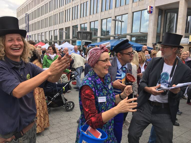 Ein Platz in einer Stadt, auf dem sich Stände und viele Menschen befinden. Ein Platz in einer Stadt, auf dem sich Stände und viele Menschen befinden.