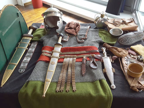 Waffen wie Langschwert und Kurzschwert und Ausrüstungsgegenstände wie Feldflasche, Kettenhemd und Helm liegen nebeneinander. Waffen wie Langschwert und Kurzschwert und Ausrüstungsgegenstände wie Feldflasche, Kettenhemd und Helm liegen nebeneinander.