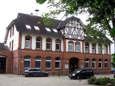 Blick auf ein Backsteingebäuden mit weißen Fassadenelementen und Fachwerk im obersten Teil. Blick auf ein Backsteingebäuden mit weißen Fassadenelementen und Fachwerk im obersten Teil.