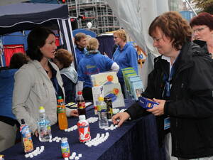 Eine Mitarbeiterin der Region Hannover steht hinter einem Stand beim Entdeckerfest. Auf einem Tresen stehen verschiedene Getränk,e vor jedem Getränk liegen Zuckerwürfel. Eine zweite Mitarbeiterin steht vor dem Tresen und platziert weitere Zuckerwürfel. Eine Mitarbeiterin der Region Hannover steht hinter einem Stand beim Entdeckerfest. Auf einem Tresen stehen verschiedene Getränk,e vor jedem Getränk liegen Zuckerwürfel. Eine zweite Mitarbeiterin steht vor dem Tresen und platziert weitere Zuckerwürfel.