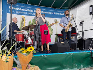 Drei Musiker und eine Sängerin spielen auf einer Bühne. Drei Musiker und eine Sängerin spielen auf einer Bühne.