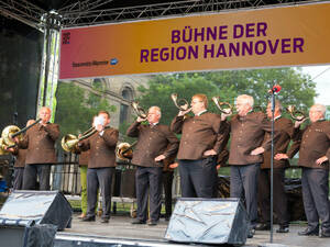 Männer in brauner Uniformjacke blasen in Jagdhörner. Männer in brauner Uniformjacke blasen in Jagdhörner.