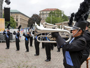 Musiker tragen eine Uniform in den Farben Blau und Schwarz und spielen auf Blechblasinstrumenten. Musiker tragen eine Uniform in den Farben Blau und Schwarz und spielen auf Blechblasinstrumenten.